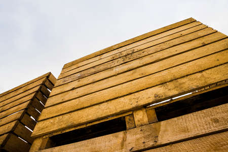 old wooden boxes for storing vegetables and fruit harvest after harvest, storage facilities on the farm, cloudy weatherの写真素材