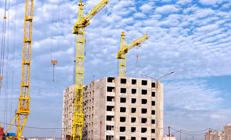 construction of a new multi-storey building for people to live in apartments, the building is being built using a high construction craneの写真素材