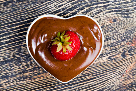 chocolate-covered strawberries on a wooden background, natural food products made at home, high-quality strawberriesの写真素材