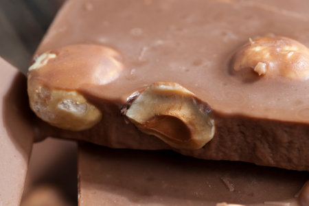 closeup hazelnuts and chocolate mixed in sweet chocolate made from cocoa and cocoa butter with nuts, hazelnuts fried and added in large quantities to sweets, quality delicious chocolate with nutsの写真素材