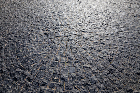 made of large dark cobblestones, close-up in the city, the road is made as an old pedestrian part of...