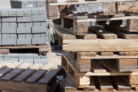 empty wooden pallets and new construction tiles for laying paths and roads, for repairing and...