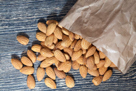 quality raw nuts ready to eat, almonds on the kitchen table during cooking, almonds fresh and peeled, close-up, the surface of the nuts is not perfect , almonds in a paper bagの写真素材