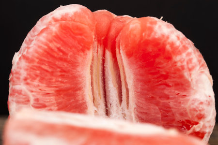 divided into whole slices delicious sour red grapefruit on the table, red citrus fruit, delicious grapefruitの写真素材