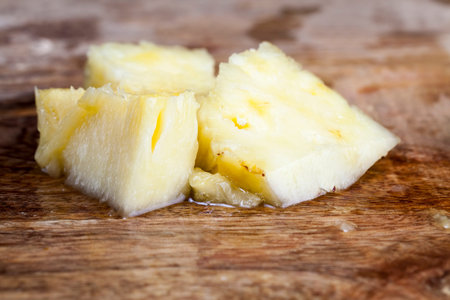 peeled ripe sweet sour pineapple, pineapple skin cut off with a knife during cooking, pineapple on...