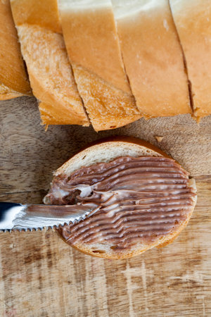 sliced white bread with sweet chocolate butter spread, soft chocolate butter and white bread,...