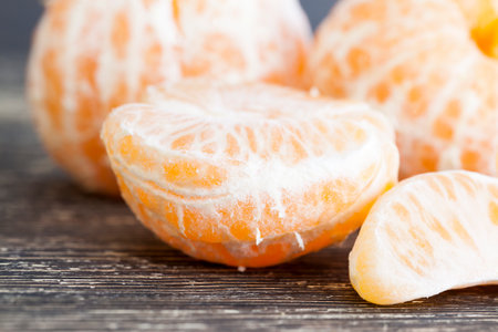 delicious tangerines, peeled orange peel lying on a wooden table, healthy citrus fruits with lots of vitaminsの写真素材