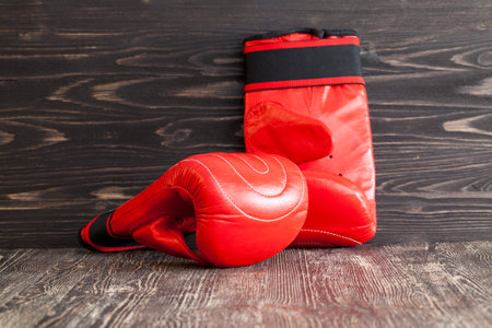 Two red new boxing gloves on a black wooden backgroundの写真素材