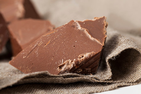 delicious high-calorie food close-up, natural edible chocolate, broken into pieces and crumbs milk...
