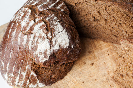 black rye bread divided into parts, fresh and soft homemade rye bread made from flour and other...