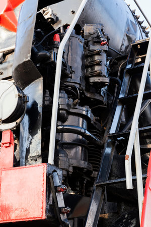 details of an old steam locomotive made of metal, painted in black and red part of the trainの写真素材