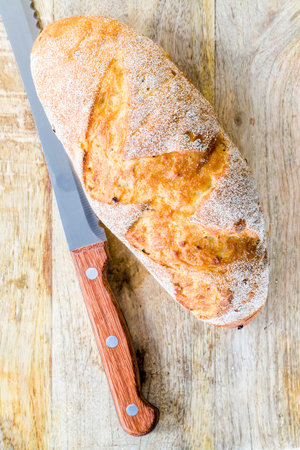 fresh and warm bread products made from wheat flour, close-up on the cutting board of delicious...