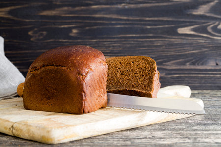 black homemade rye flour bread, close-up of food on kitchen cutting Board, cooking lunch