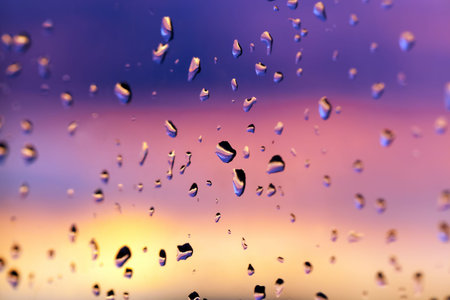 beautiful red bright clouds during sunset or sunrise, raindrops on the glass, out of focus