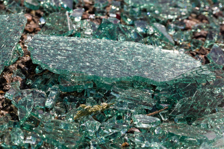 broken into very small pieces of car glass on the asphalt after an accident committed with a car,...