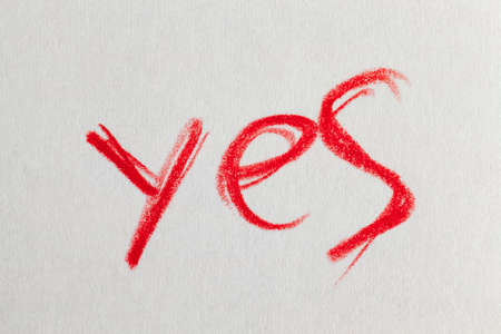 word Yes drawn in red pencil on ordinary paper of poor quality, close-up of homemade Amateur drawingの写真素材