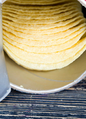 real crispy and salty potato chips ready to eat, close-up of unhealthy food products, chips from gratified mashed potatoes with additivesの写真素材