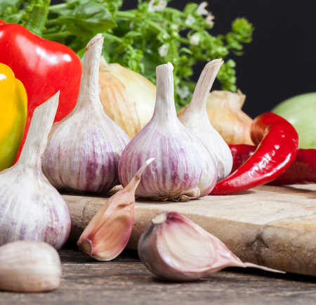vegetables on the table during cooking, garlic, pepper onions, vegetables and spices on the cutting Boardの写真素材