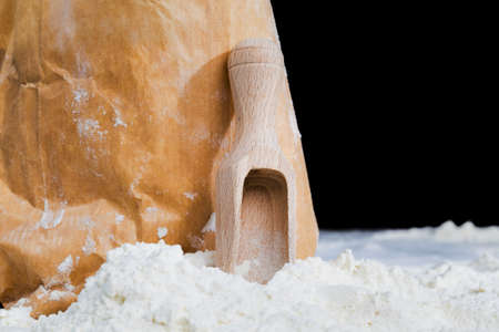 white wheat flour in a paper bag with wooden spoon, collected parts ingredients for cooking pasta from durum wheatの写真素材