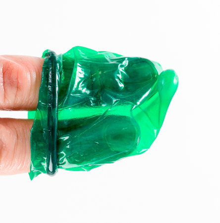 green latex condom to prevent pregnancy and STDs and infection, close-up and small depth of fieldの写真素材