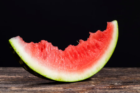 bitten piece of red watermelon with sweet delicious pulp, close-up of watermelon pulp in summer