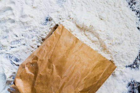 a paper bag of flour on the table, some white wheat flour spilled out of the bagの写真素材