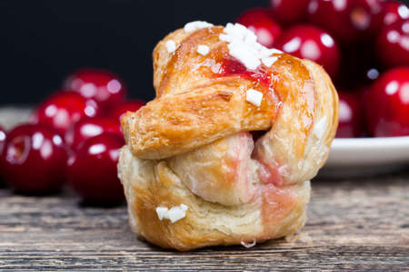 homemade bun made from flour and filling in the form of cherry red jamの写真素材