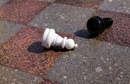 huge plastic chess pieces on a stone chessboard for relaxing and playing chess on the street, chess...