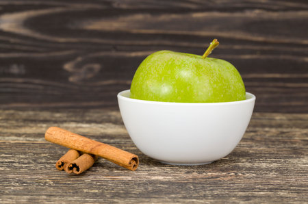 in the peel of a green Apple and fragrant cinnamon on a wooden cutting Board, close-up of food of...