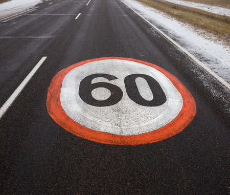 The road sign is drawn on an asphalt road indicating the speed limit in the villageの写真素材