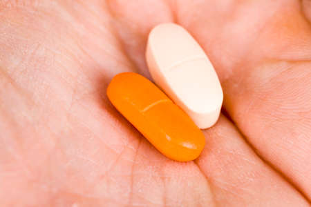two types of medicinal pills are in the human hand, close-up of a variety of pillus medicationsの写真素材
