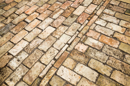 part of a park road made of yellow brick, modern worn roads