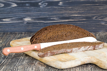 black rye bread cut in chunks on a cutting Board, close-up of traditional food in Eastern Europe