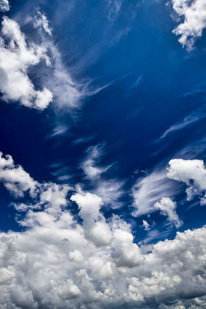 a beautiful blue sky lit with bright sunlight with white clouds of various shapes, a beautiful summer landscapeの写真素材