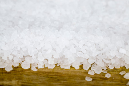 large coarse salt on the Board, spices used in cooking, close-up and small depth of field