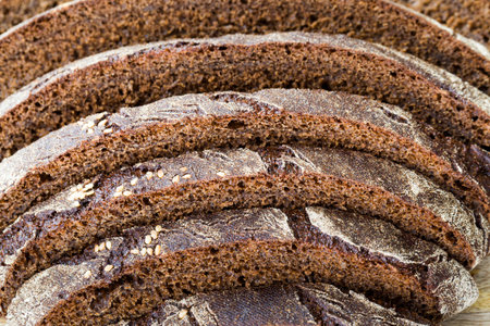 baked dark-colored rye flour loaf of bread, cut into pieces during table setting