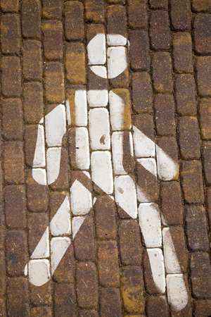 painted with white paint on a block road the figure of a man, part of the road for pedestrians, top view close-upの写真素材