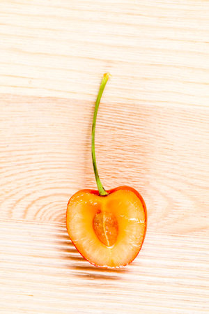 sliced yellow cherries on a white wooden table, preparation of cherries for use in cooking