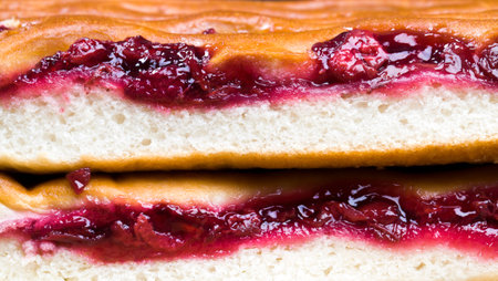 plain cake of wheat flour and cherry jam, cut into pieces, close-up of baking