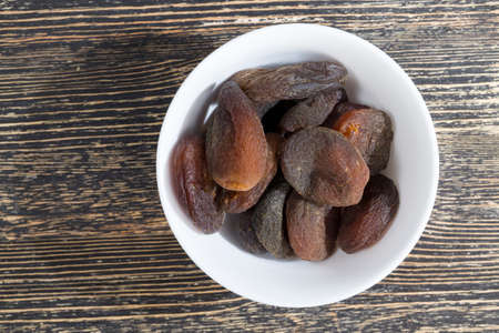 small dry apricots traditional food in Eastern countries, close - up of dried fruit in a white plateの写真素材