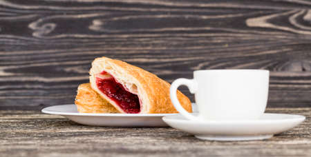 real sweet and fresh cherry buns with red sweet jam and berries inside, the food on the table is blackの写真素材