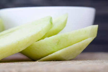 sliced green ripe and juicy Apple, lies on a cutting Board made of natural materials