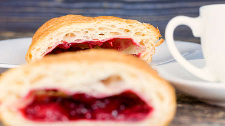 real sweet and fresh cherry buns with red sweet jam and berries inside, the food on the table is blackの写真素材