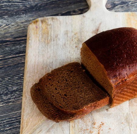 black bitter rye flour bread, close-up of food on kitchen cutting Board