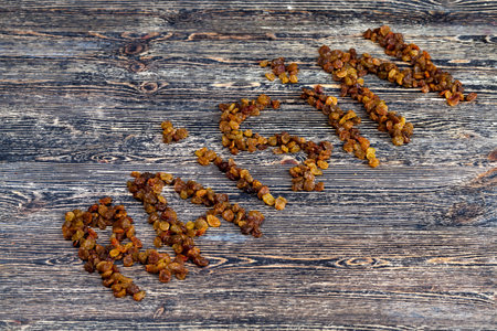 word raisins from dried grapes - raisins on a wooden primitive table, closeupの写真素材