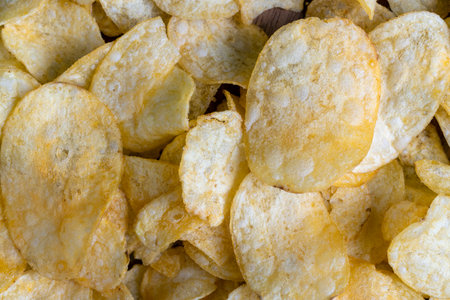 scattered potato chips with natural spices, fried potato chips with spices and flavorings in oilの写真素材
