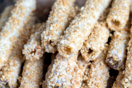 waffle tube with chocolate filling and crushed peanuts, sweet waffle tubes with fried pieces of...