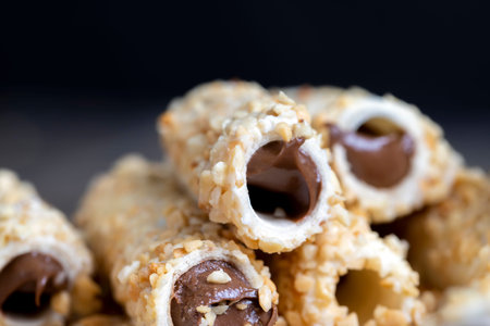 waffle tube with chocolate filling and crushed peanuts, sweet waffle tubes with pieces of peanuts...