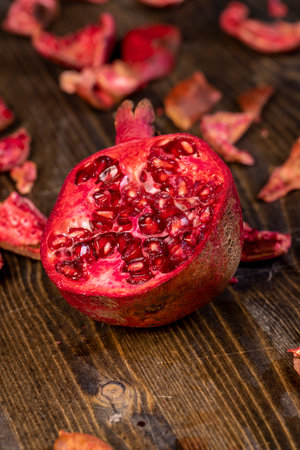 sliced red pomegranate on a black table, sweet red pomegranate cut into pieces, close up