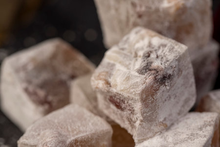 cubes of Turkish delight with the addition of dried red berries in powdered sugar closeup